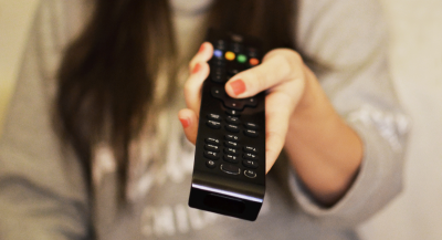 Hand einer Frau mit Fernbedienung