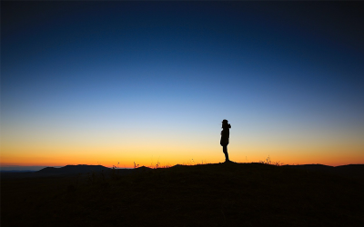 Person schaut einsam auf Sonnenuntergang